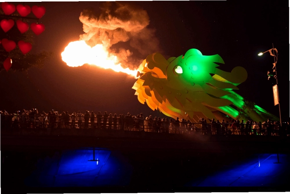 Tourists gather to witness the spectacular fire-breathing show at Dragon Bridge